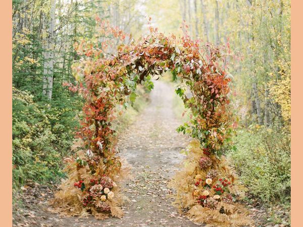 Ceremony arch made from fall-colored flowers and dried foliage