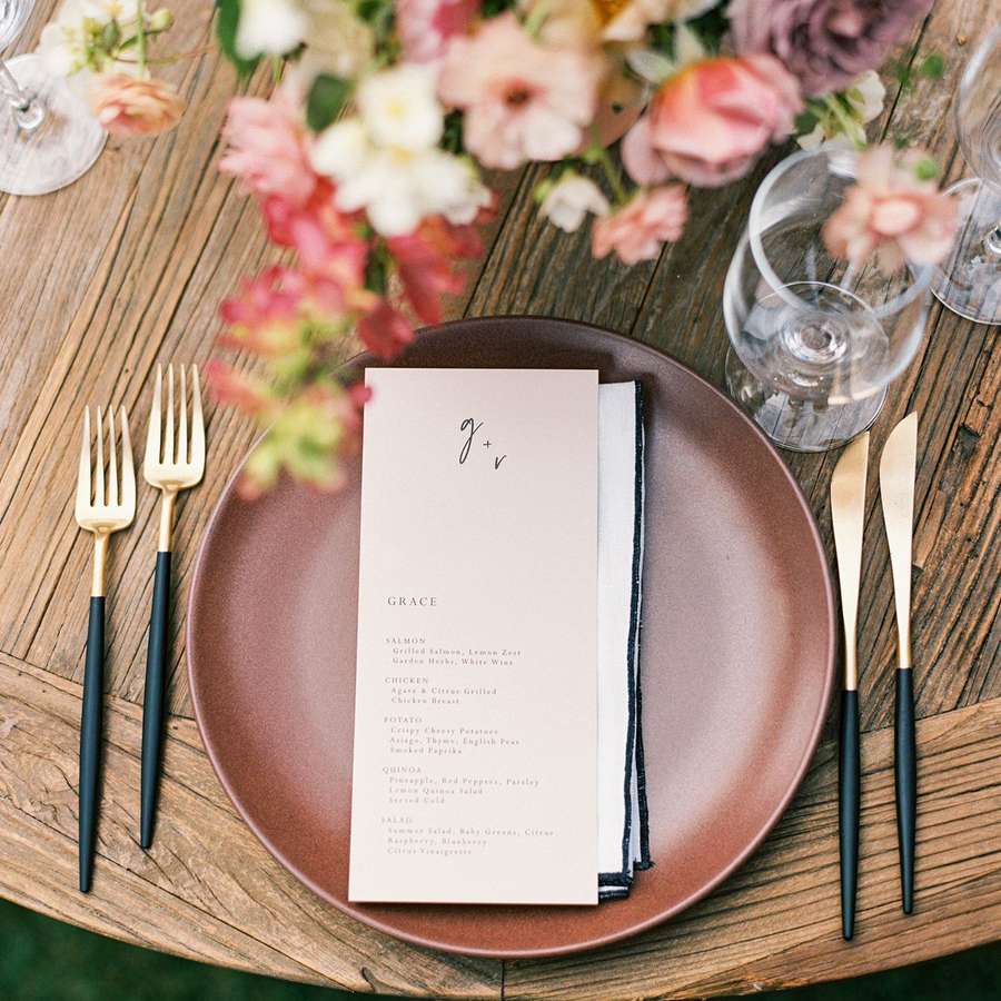 summer wedding place setting with a colorful flower arrangement and a paper menu