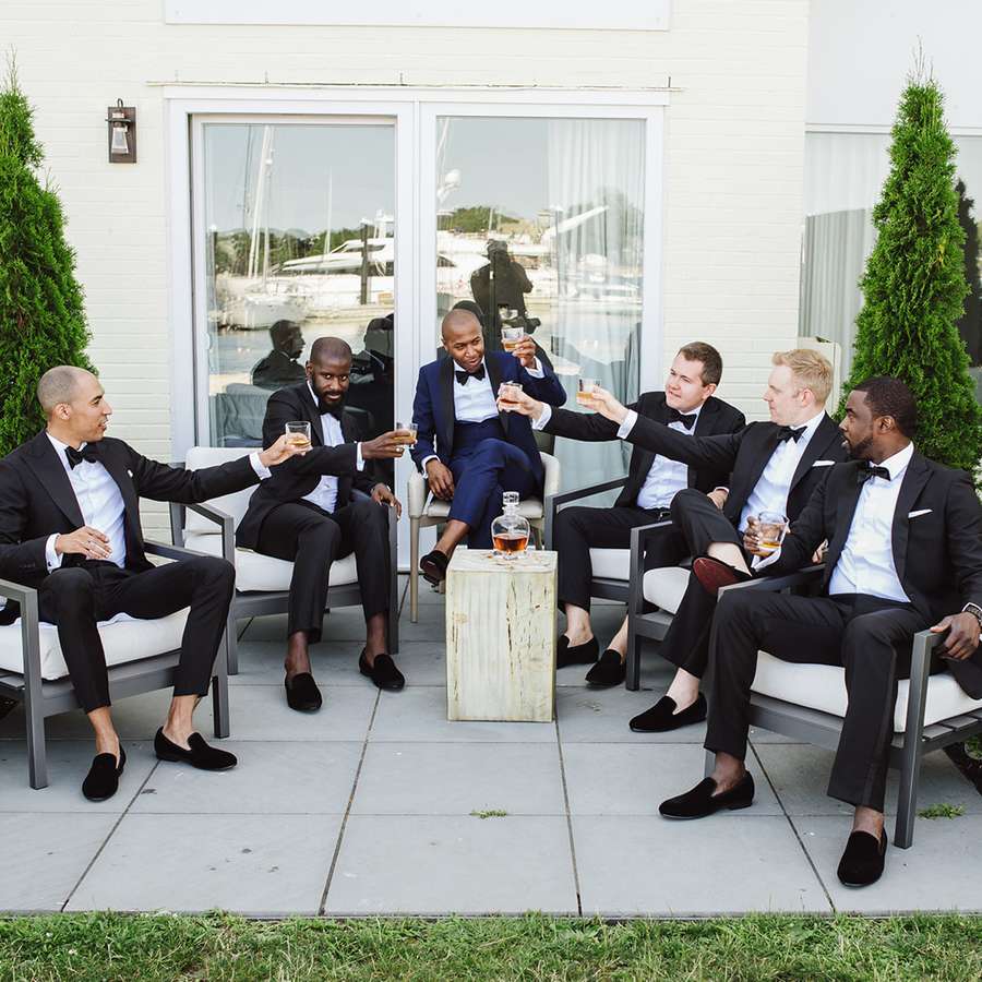 Groom and five groomsmen toasting with Scotch on wedding day
