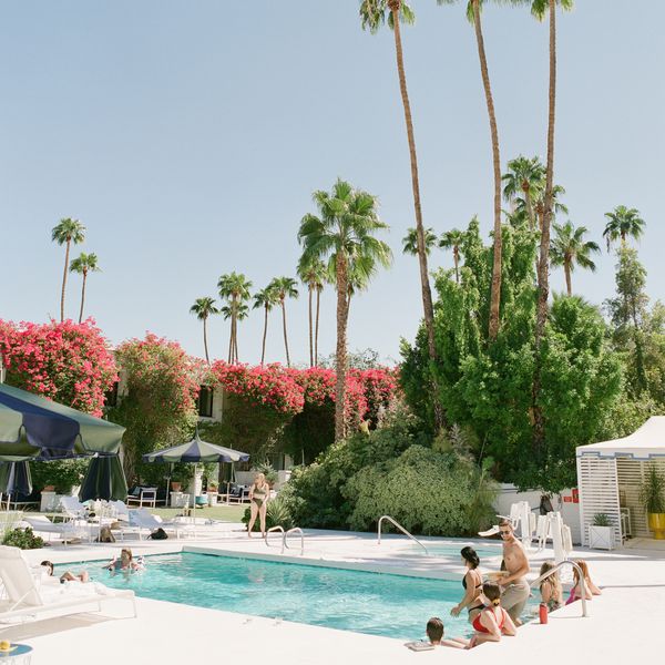 guests at pool in palm springs, california, with palm trees in background