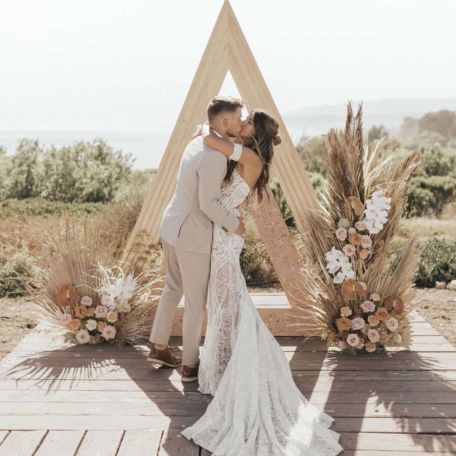 boho bride and groom kissing at the alter
