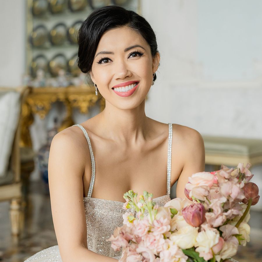 bride smiling for her bridal portrait holding a bouquet of flowers