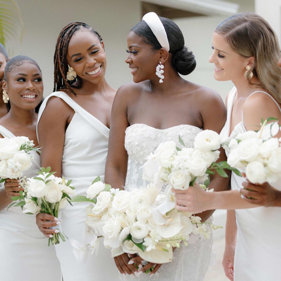 Bride in headband with bouquet and her bridesmaids in white dresses holding bouquets
