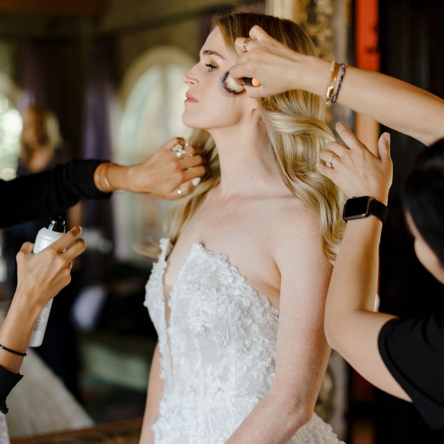 a bride getting her hair and makeup touched up
