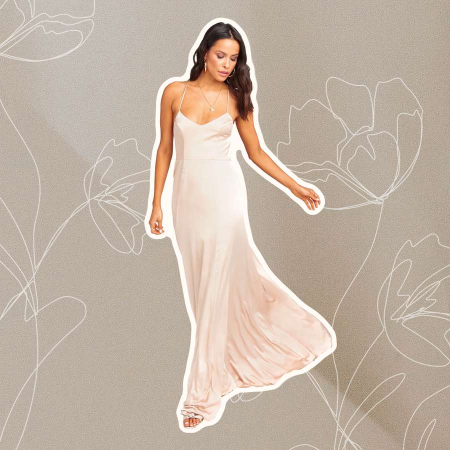 A person wearing a champagne bridesmaid dress on a simple, flowery background