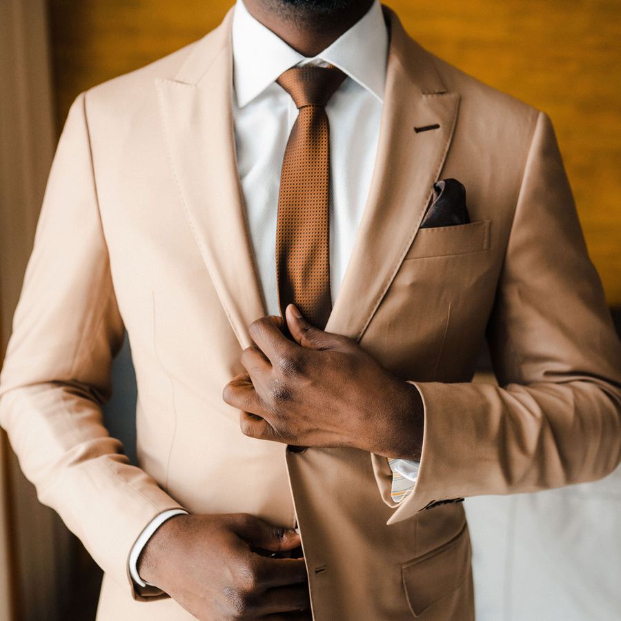 a tan suit with a brown tie