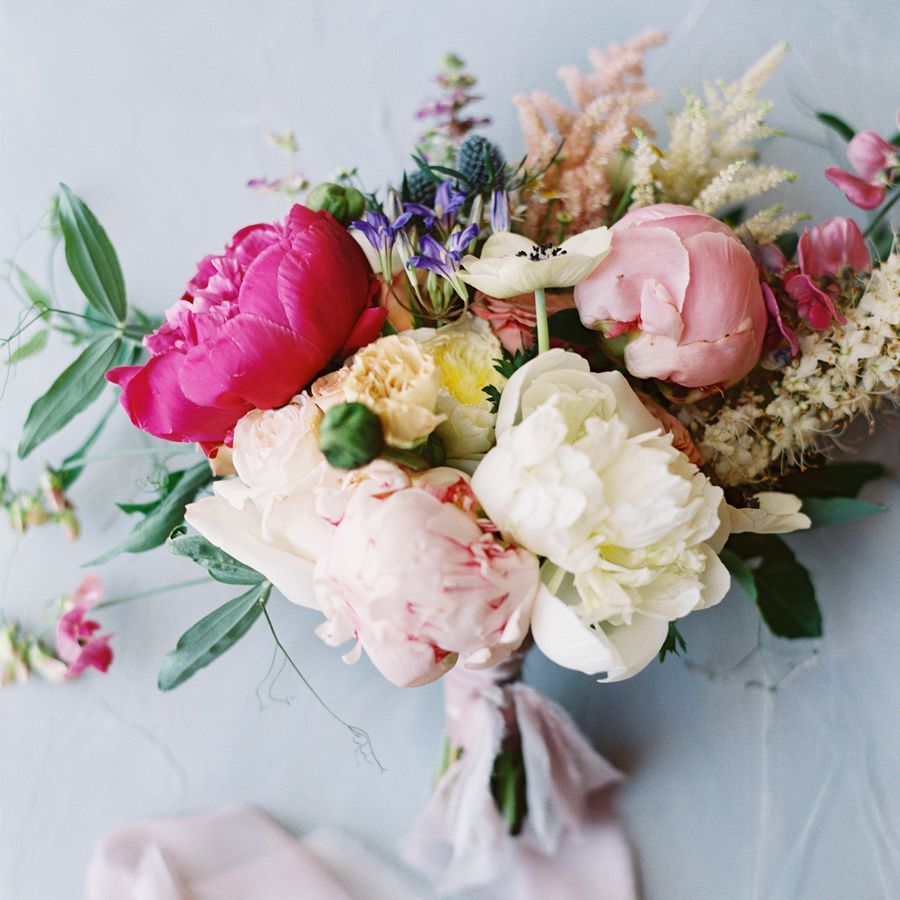 Pastel wedding bouquet with peonies wrapped in pink ribbon