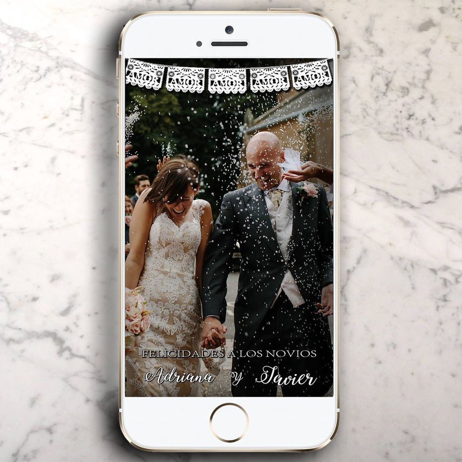 iPhone on a marble counter top with a wedding photo and geofilter in Snapchat