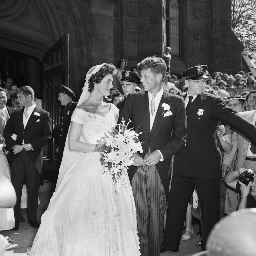 Jackie Kennedy and John F Kennedy looking at one another outside of their church ceremony venue in Newport, Rhode Island
