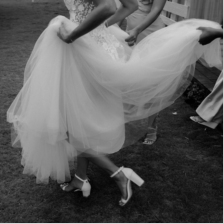 bride wearing lifting up the skirt of her ball gown to expose her shoes