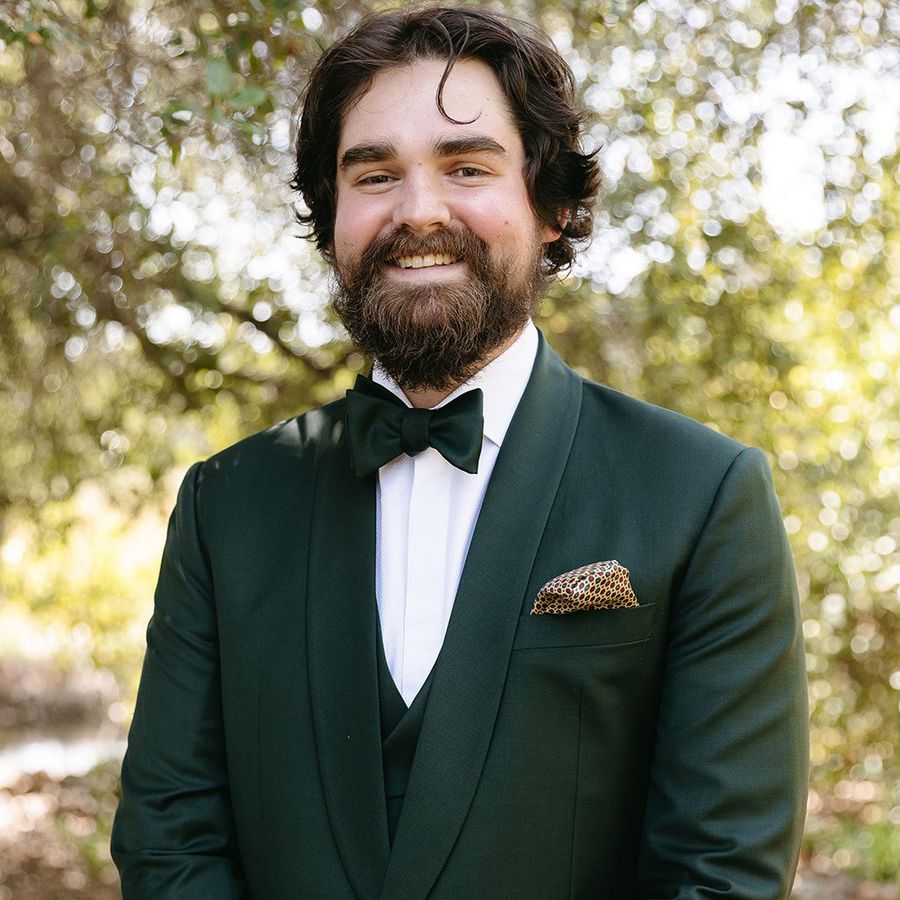 groom in hunter green suit and polka dot pocket square