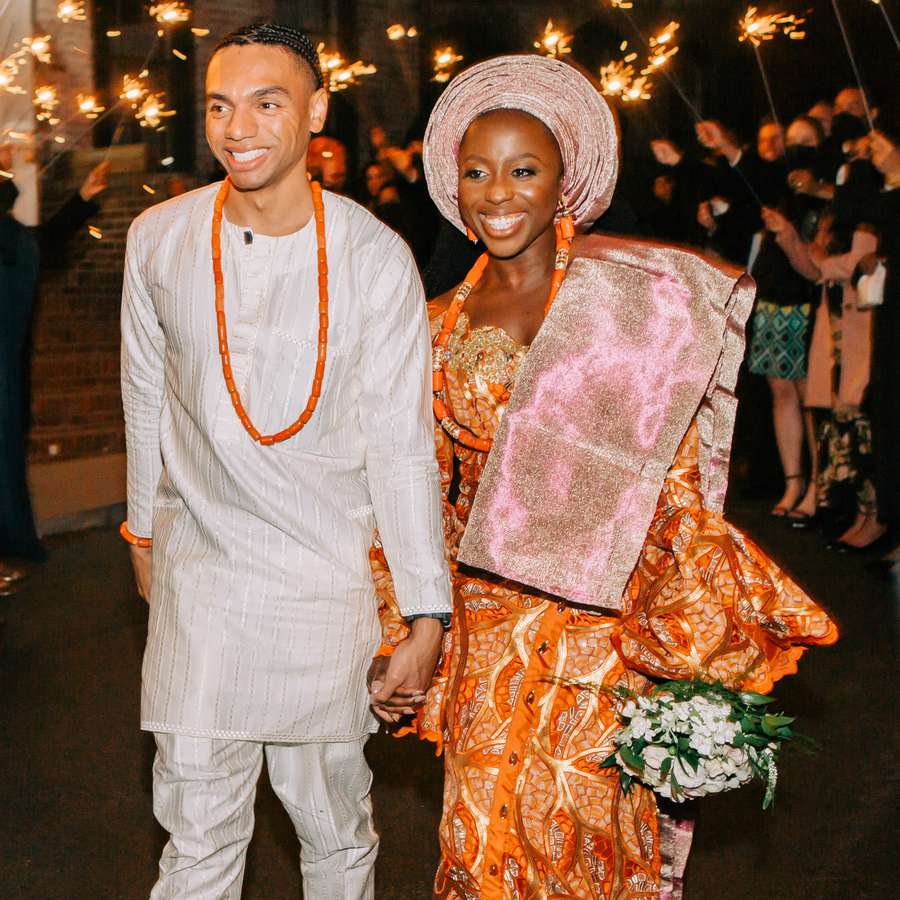 nigerian couple leaving their wedding reception amongst a sea of sparklers