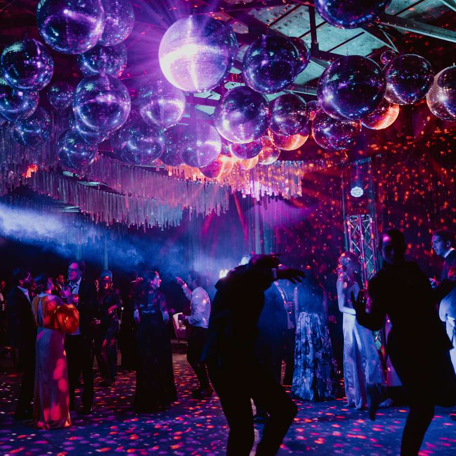 Wedding reception with disco balls while guests dance.