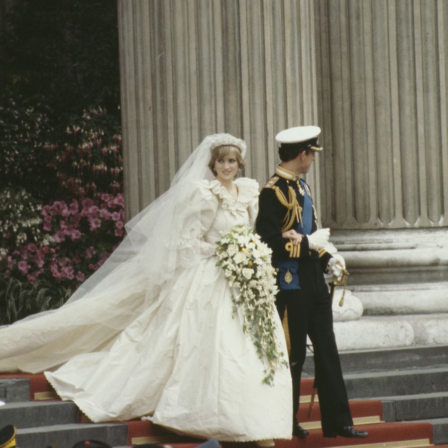 Princess Diana in her silk taffeta wedding dress linking arms with King Charles outside of St. Paul's Cathedral