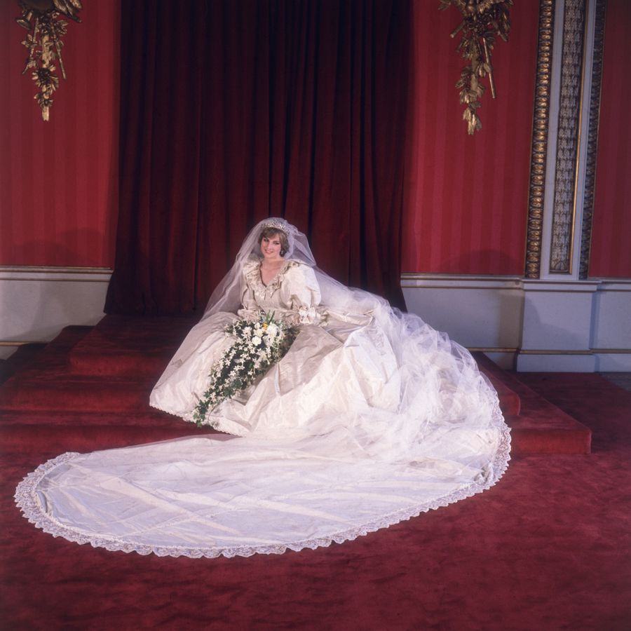 Princess Diana sitting on the floor in her taffeta ball gown with puffy sleeves and a long train