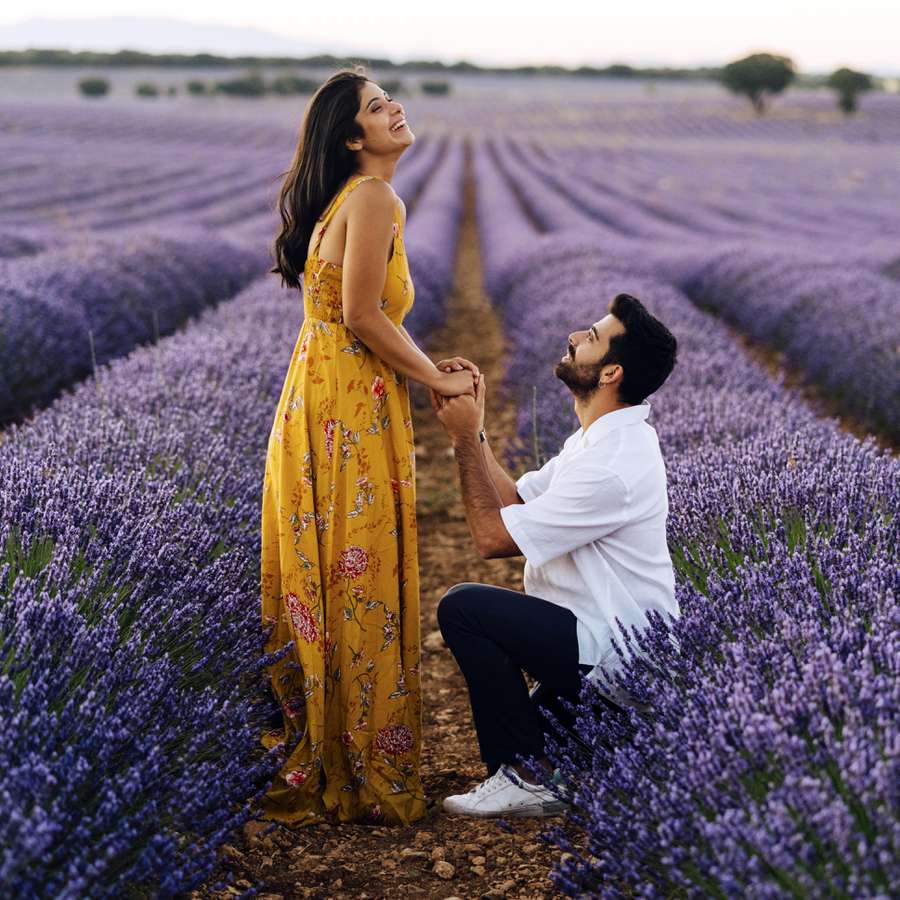 Man proposing woman standing in lavender field