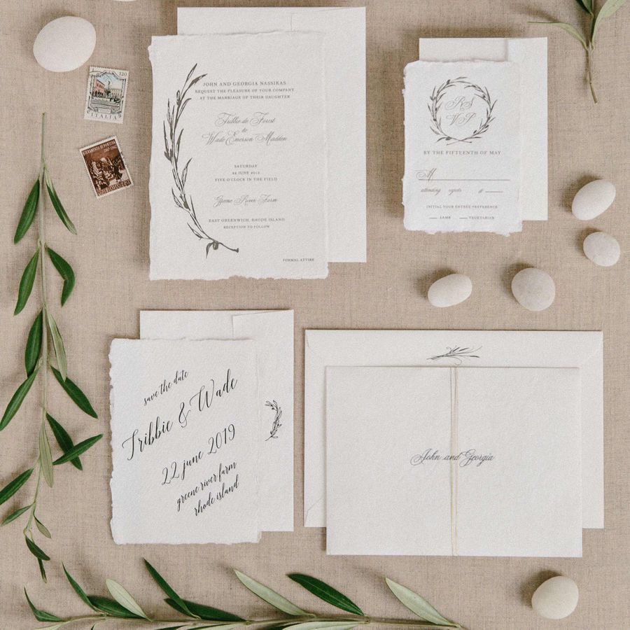 White invitation suite with olive branch accent with save the dates, olive branches, stamps, and stones
