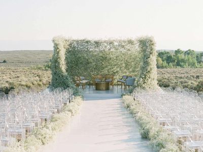 Baby's breath-lined aisle, ghost chairs, and bold baby's breath mandap