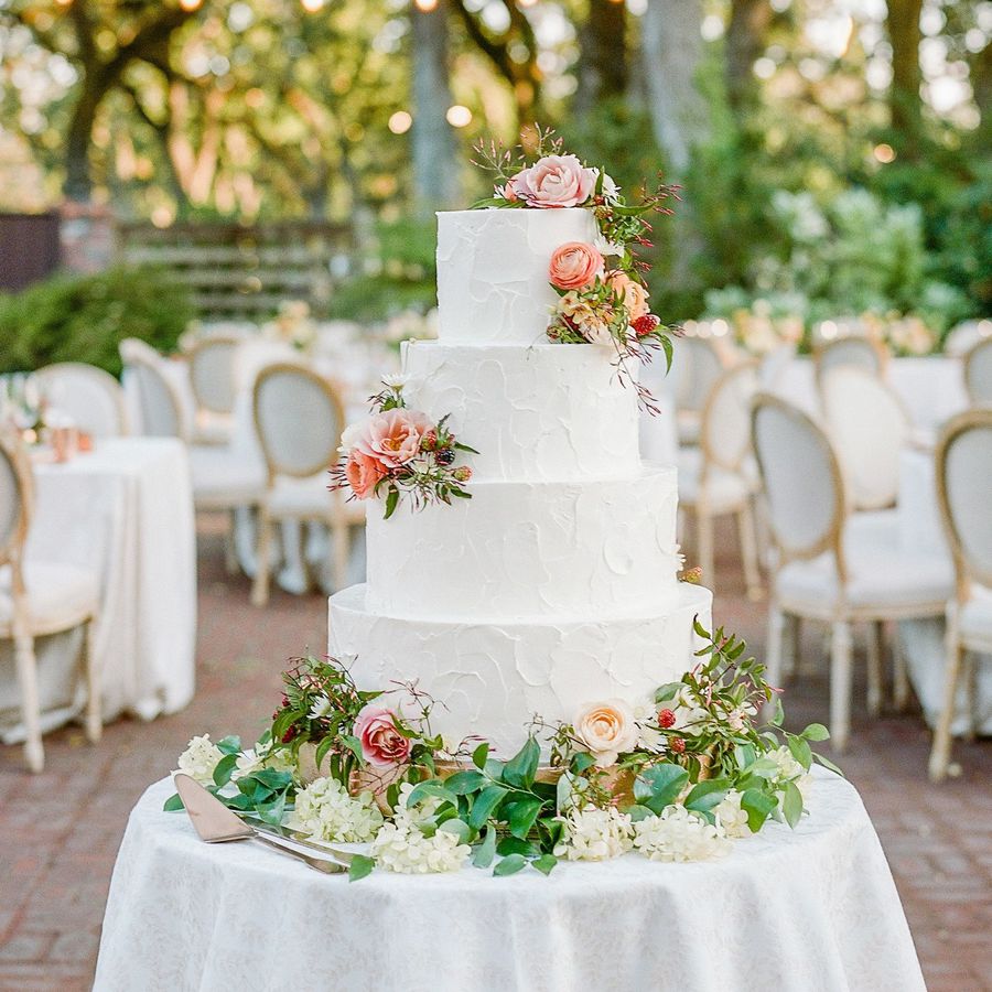 White wedding cake with fresh flowers and four tiers