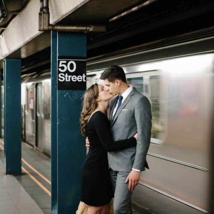 Engaged couple kissing next to the subway