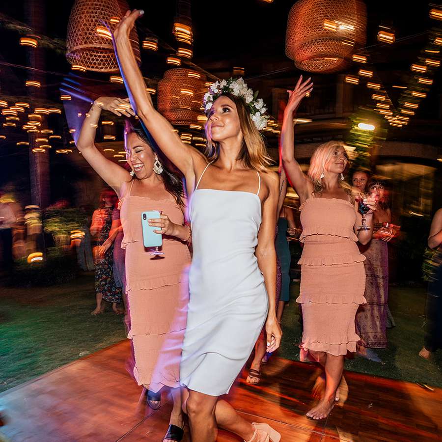 Bride and bridesmaids dancing at outdoor nighttime reception