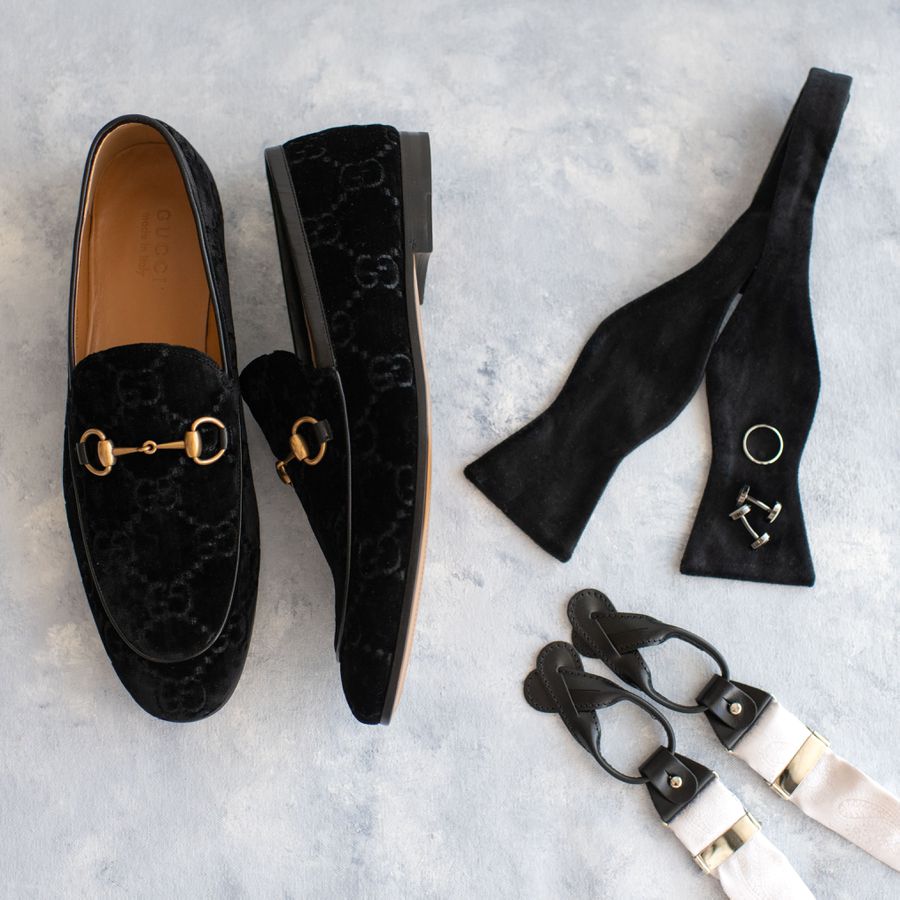 velvet men's loafers, an untied bowtie, cufflinks, and a wedding band