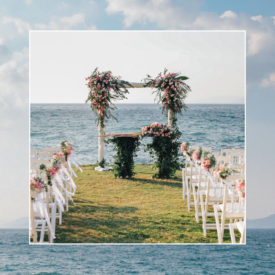 A wedding ceremony altar with flowers by the ocean.