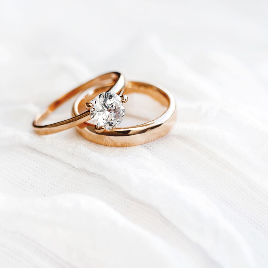 A stack of a diamond engagement ring and a gold wedding band