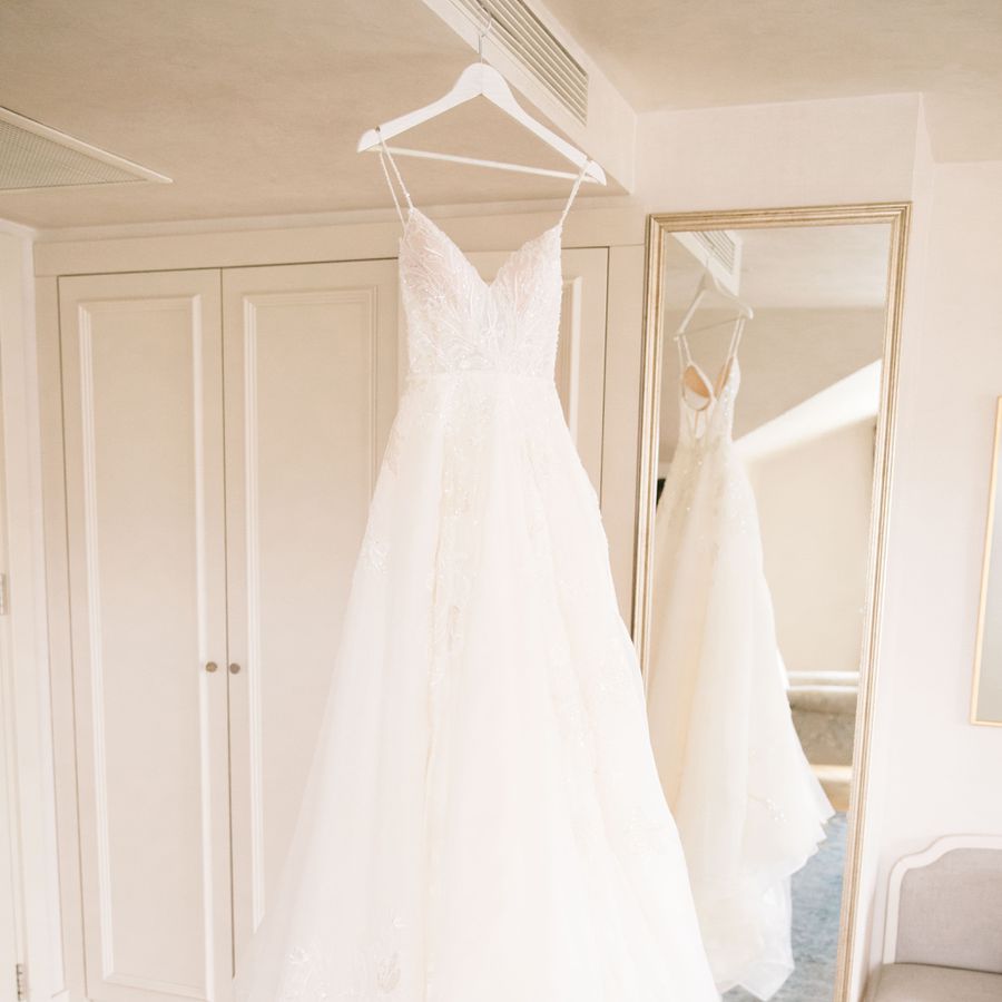 Embellished wedding dress on a hanger in a room