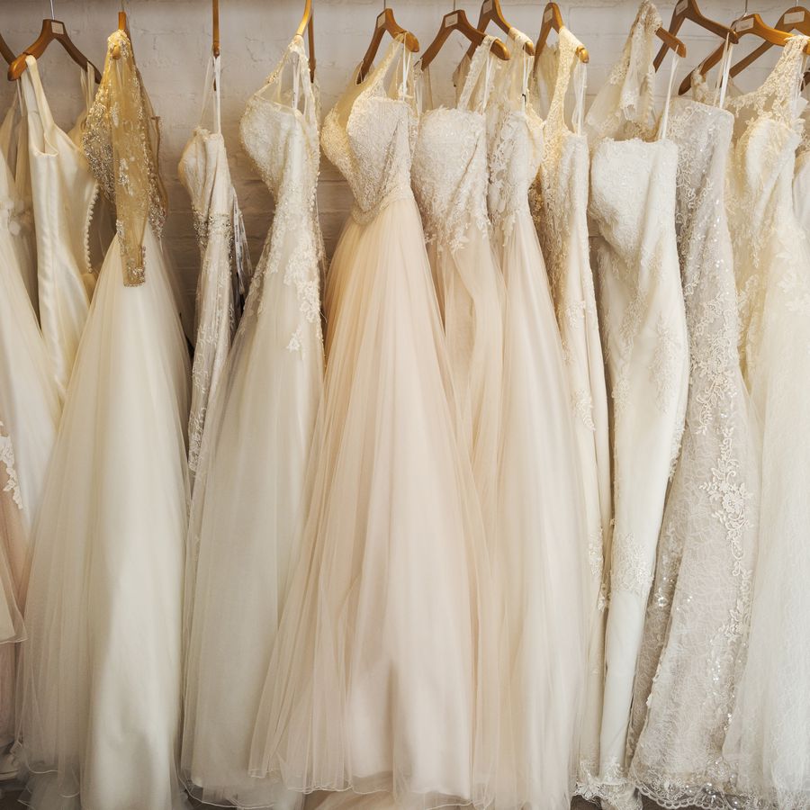 A rack of wedding dresses on wooden hangers