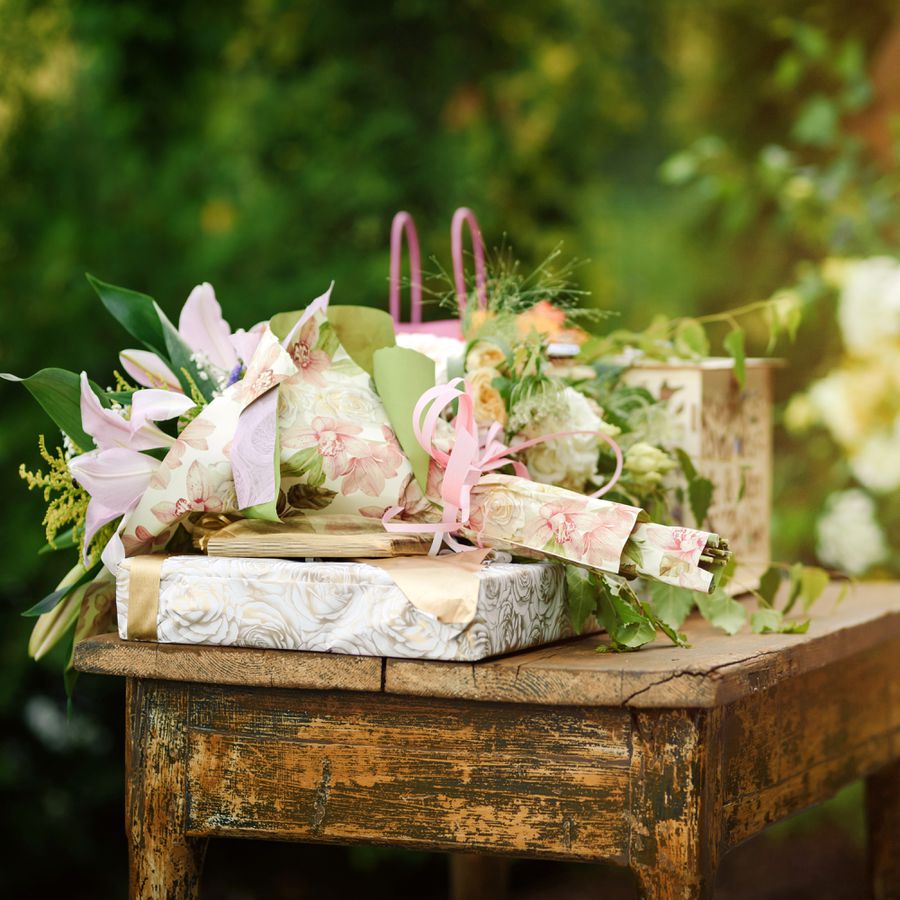 Wrapped Wedding Gifts on Rustic Wooden Table with Flowers