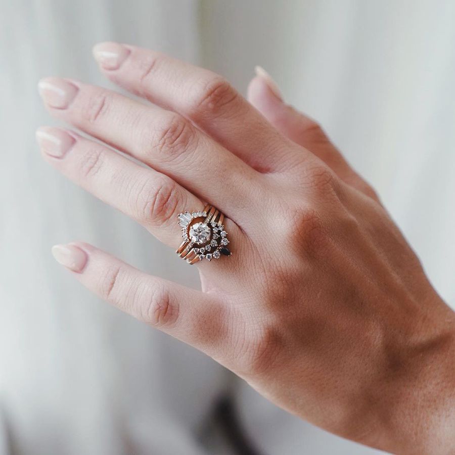 a woman's hand wearing a wedding ring stack 