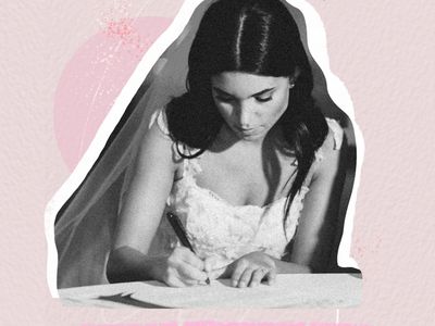 Black and white image of a bride in a white wedding dress signing her marriage license. 